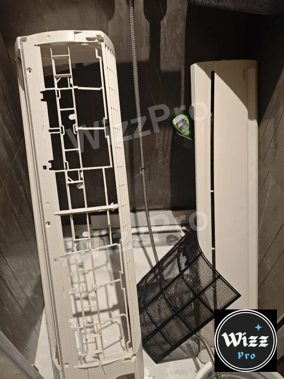 拆下的白色冷氣外殼及隔塵網放在浴室內